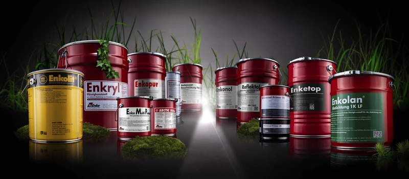 Enke-Produktfamilie aus Eimern und Dosen vor schwarzem Hintergrund mit Gras.