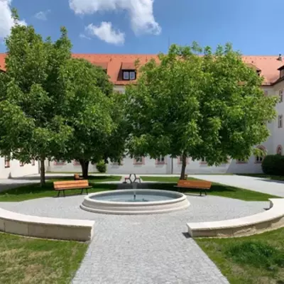 Abbildung eines Brunnens vor einem historischen Gebäudes