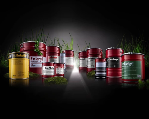 Enke-Produktfamilie aus Eimern und Dosen vor schwarzem Hintergrund mit Gras.